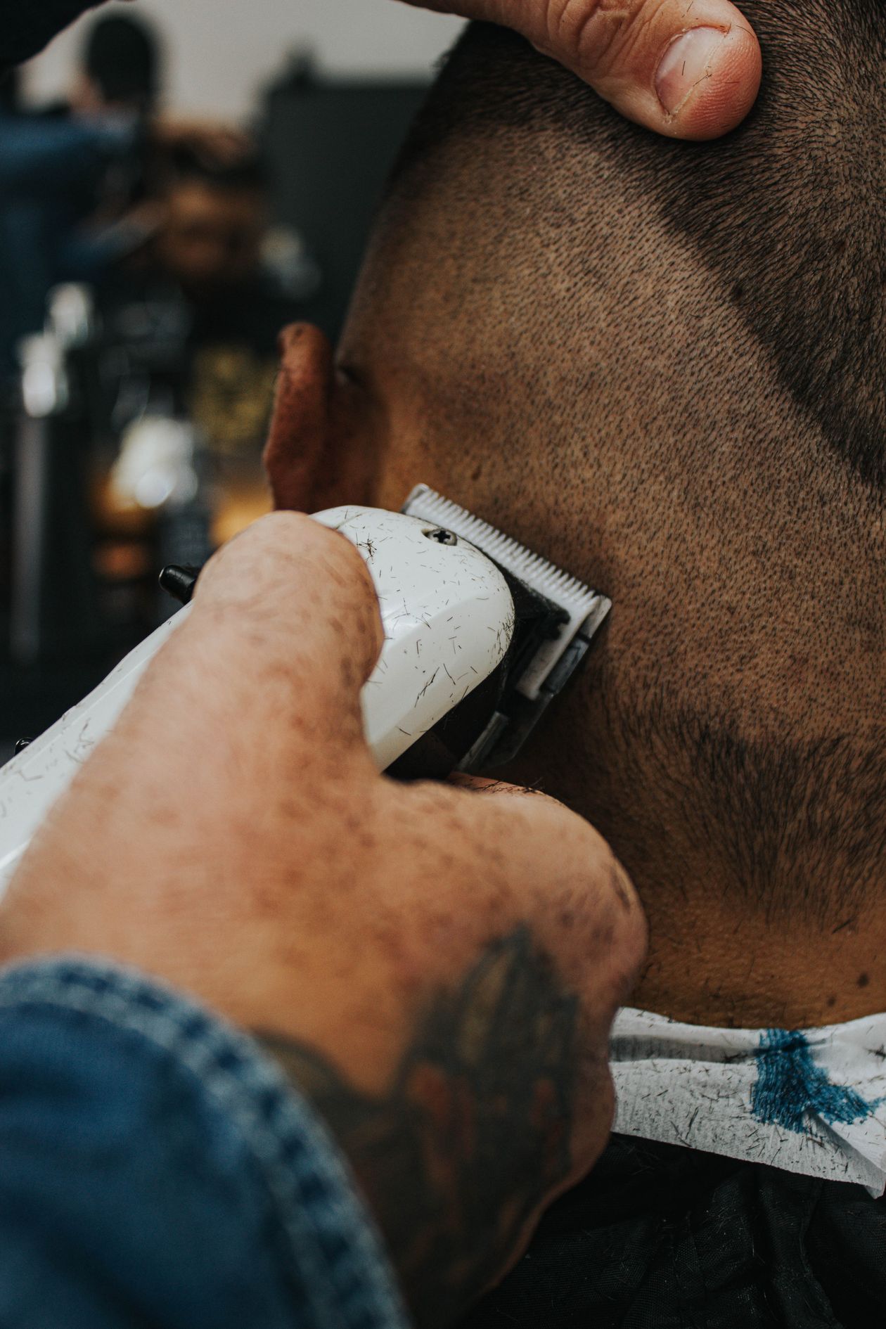 Barber detailing a fade with electric clippers